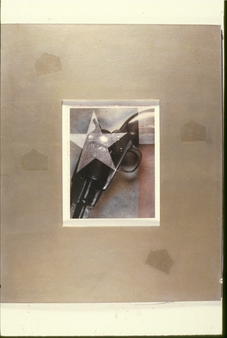 A multiple exposure with a close-up of a black pistol and a faded Texas state flag. Red handwriting follows the white edges of the print, framed by a larger brown mat stamped with a silhouette of the Alamo.